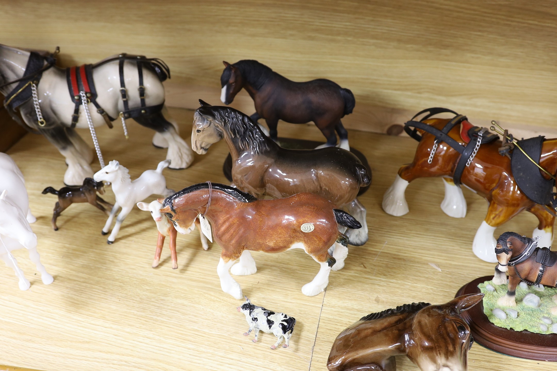 A collection of mixed Beswick, horses, to include cart horses a wall pocket, white glazed horse and a Border Fine Arts Clysdale Stallion